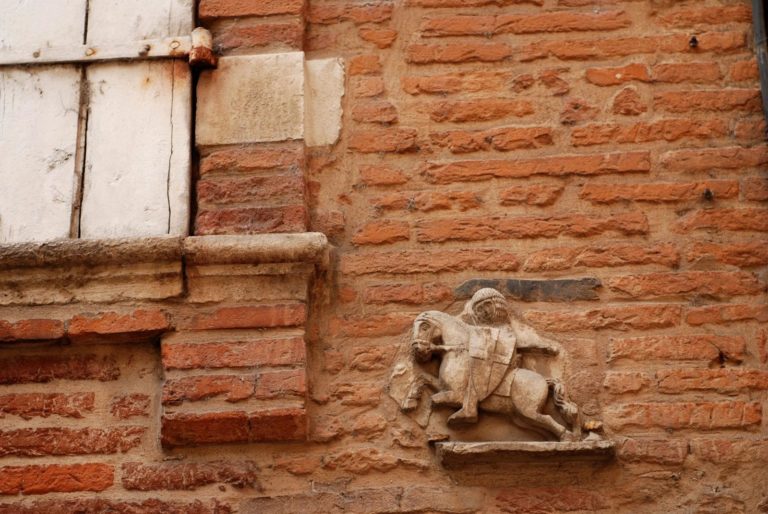 Photo de mur porteur en brique avec petit bas relief d'un personnage sur un cheval